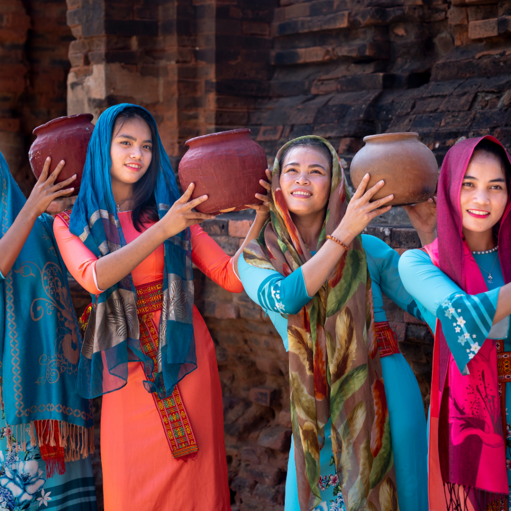 Vrouwen in traditionele kleding dragen kruiken tijdens een culturele tour.