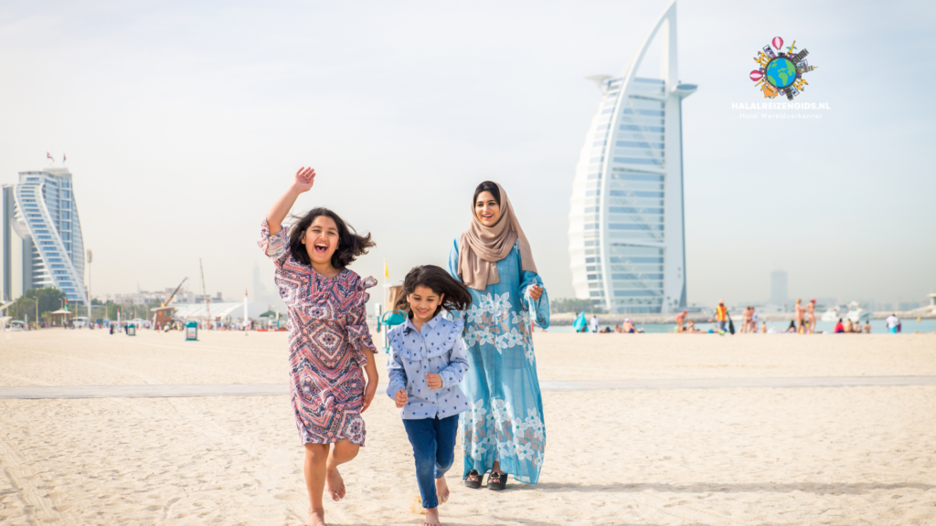 Familie geniet van een halal vakantie op het strand van Dubai met de Burj Al Arab op de achtergrond.