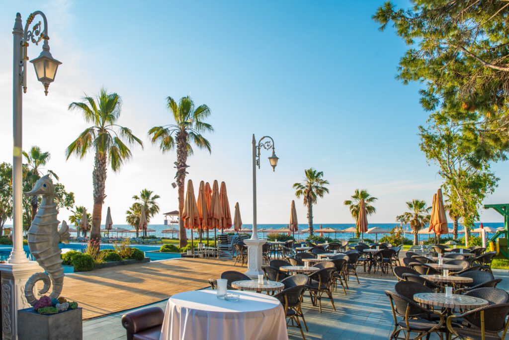 Buitenrestaurant met uitzicht op zee en palmbomen, ideaal voor een halalvriendelijk diner.