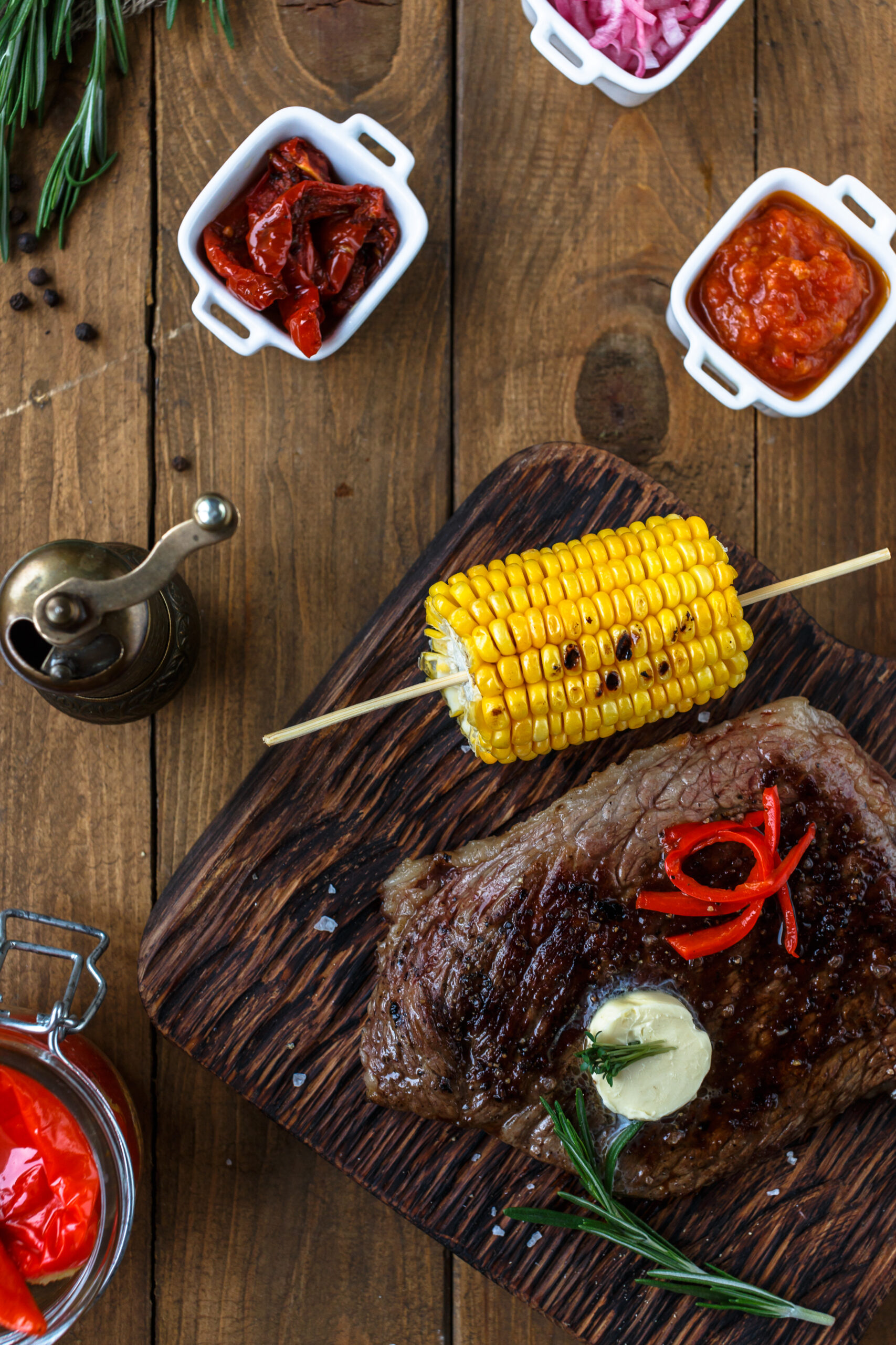 Gegrilde halal steak met maïs, boter en kruiden, geserveerd op een houten bord in Dubai.