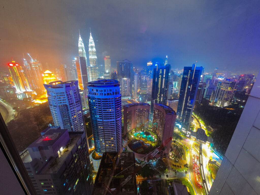 Nachtelijke skyline van Kuala Lumpur met de verlichte Petronas Twin Towers, een top halal vakantiebestemming in Maleisië.